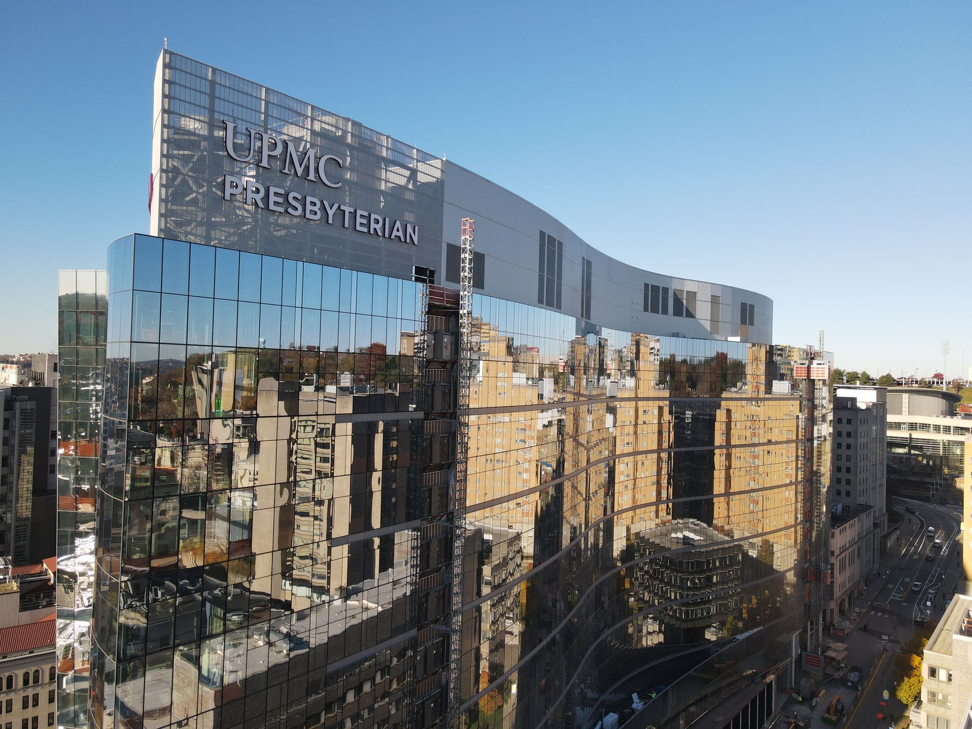 UPMC Presbyterian Hospital building with reflective glass exterior.  Bright sunlight on a clear day.