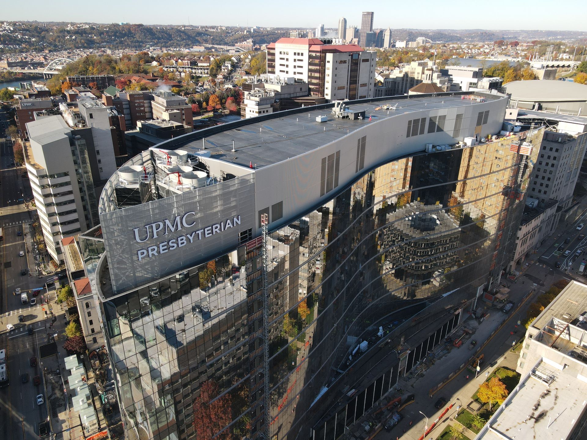 UPMC Presbyterian Hospital building with reflective glass exterior in an urban setting.