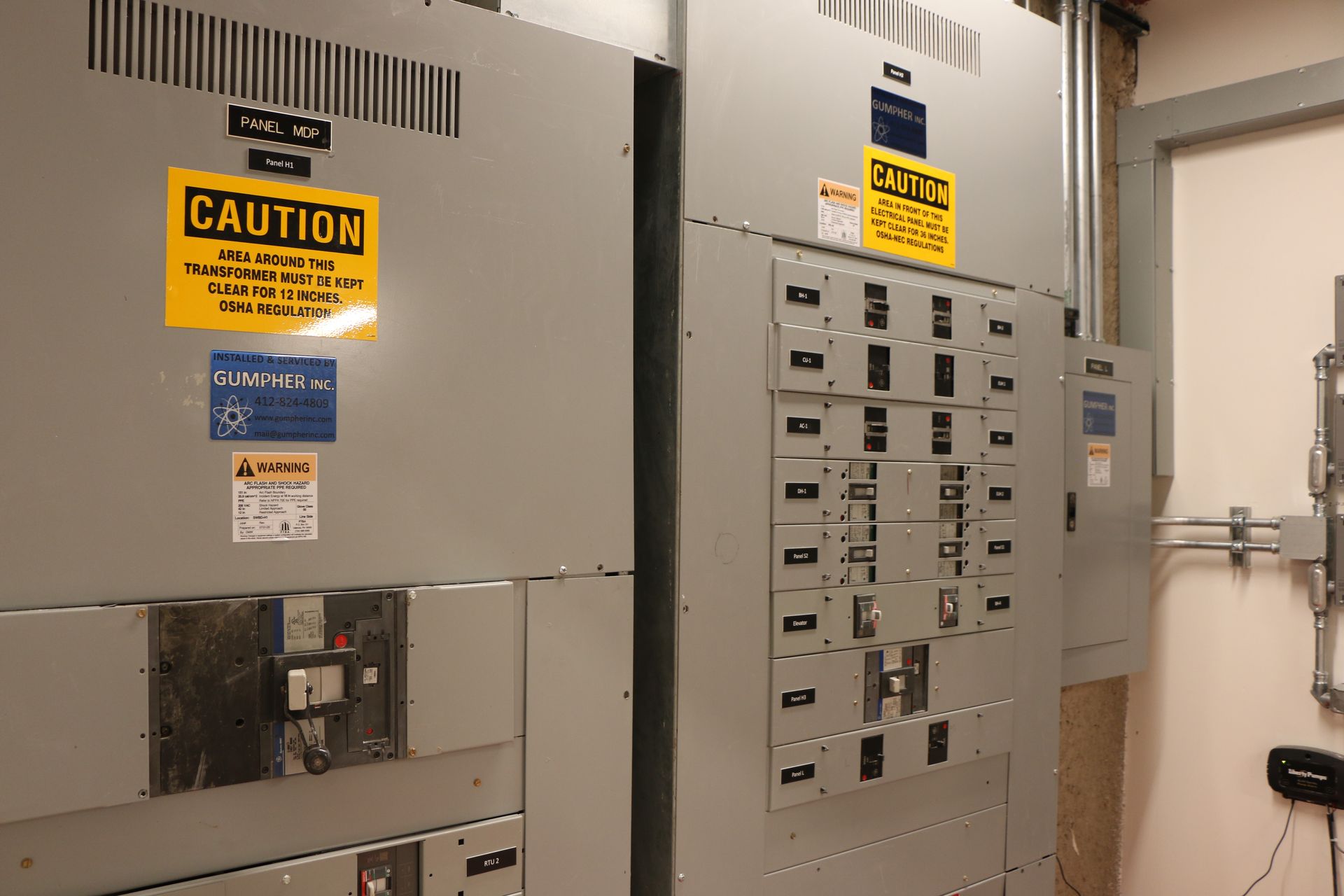 Electrical panel with caution signs in a utility room.