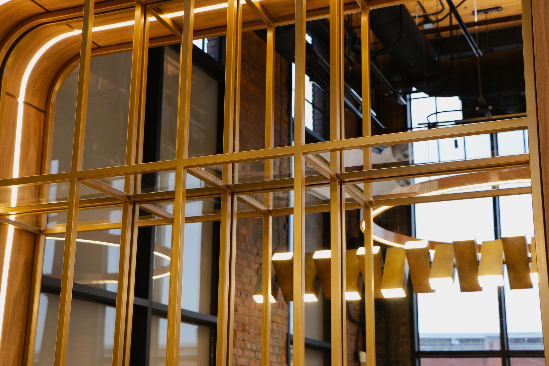 Gold metal frame in front of a window with arched wood trim.  Warm lighting.