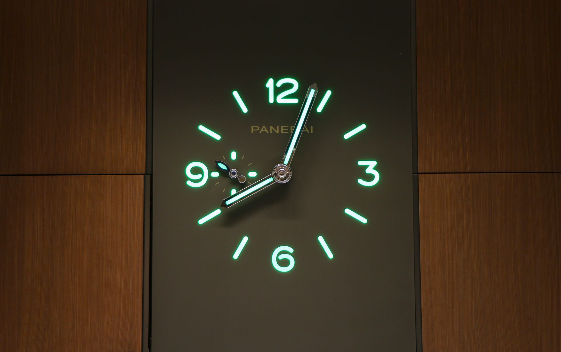 Glowing clock face with green numerals and hands; 