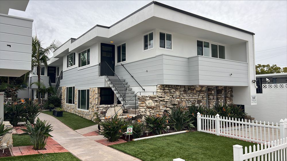 A white house with a white picket fence in front of it