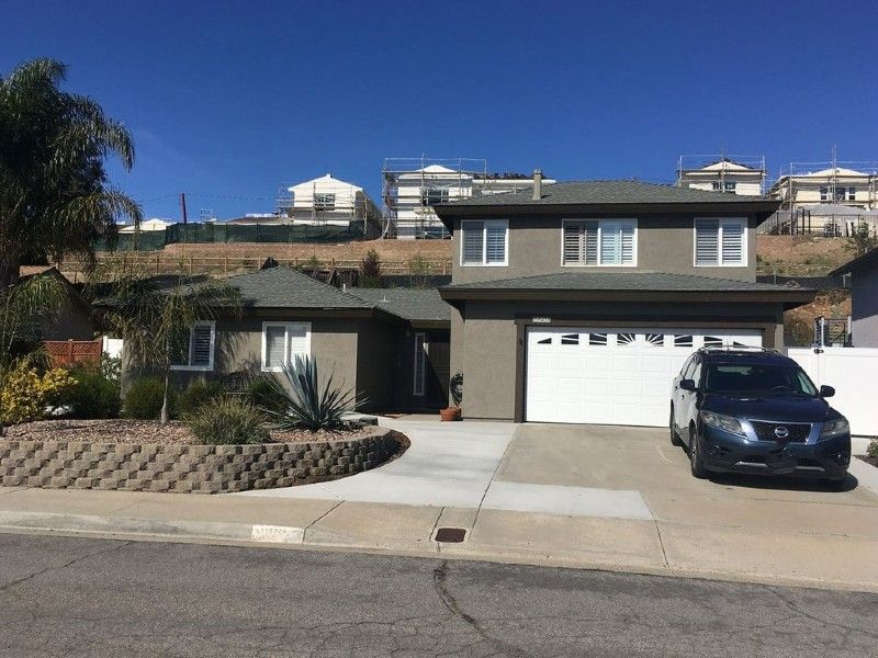 A car is parked in front of a large house
