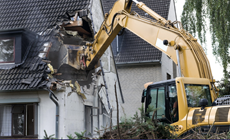 Demolishing a house with a backhoe