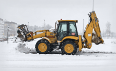 Removing snow by backhoe