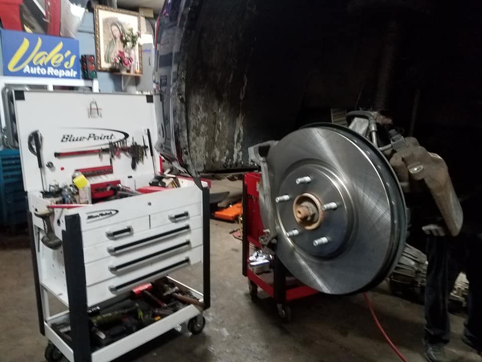 New brake rotor being installed at a repair shop, next to a Blue-Point tool cart.