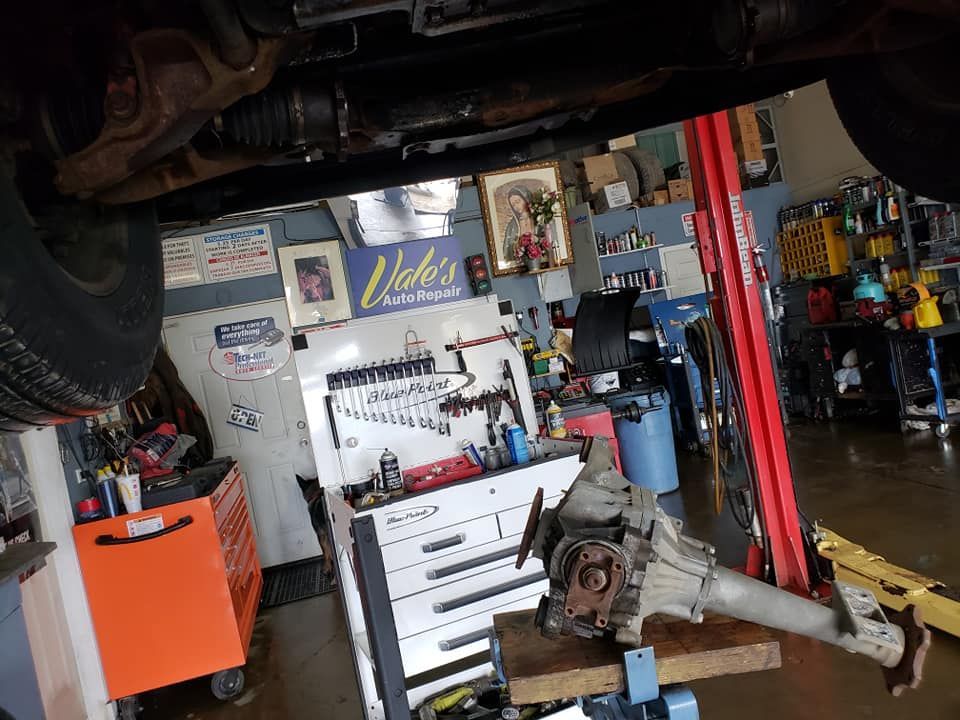 Undercarriage of a vehicle in an auto repair shop with a rear differential on a work stand.