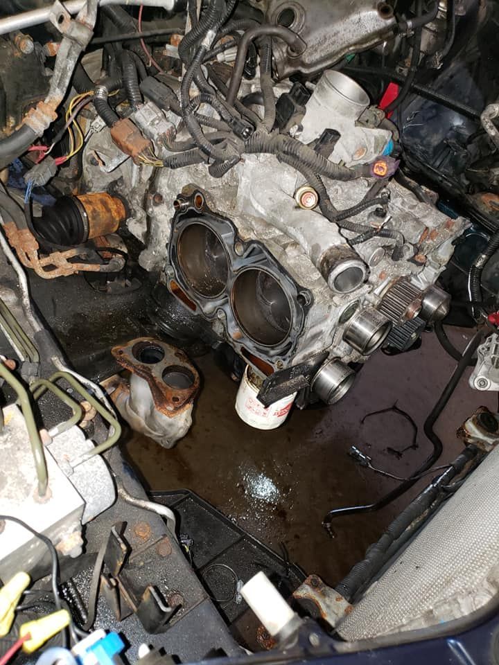 Engine block with removed cylinder heads, various parts, and spilled fluid.
