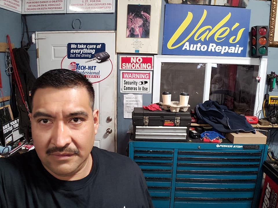 Man in a garage, next to a toolbox. 