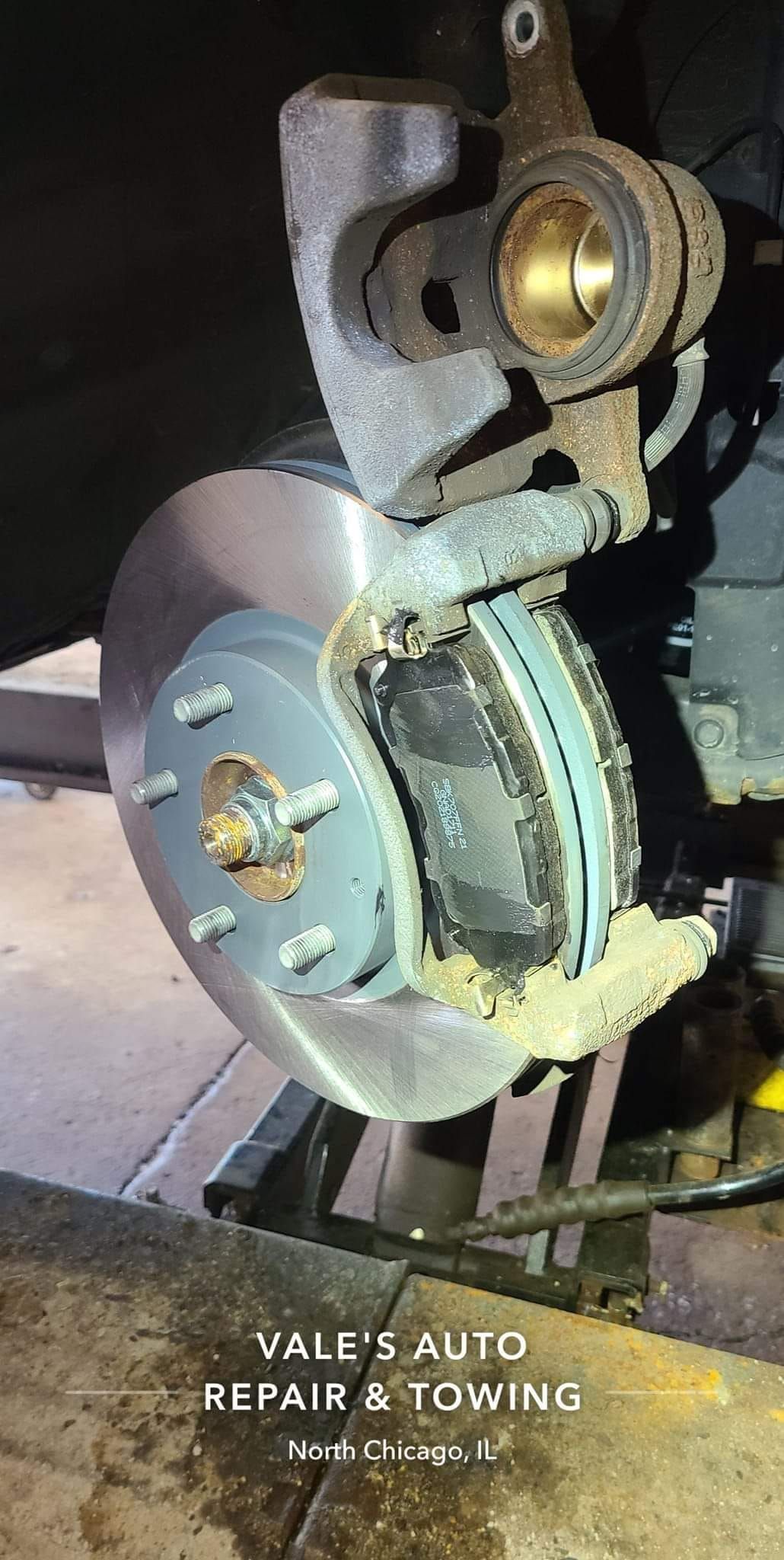 Car brake rotor and caliper assembly during repair.