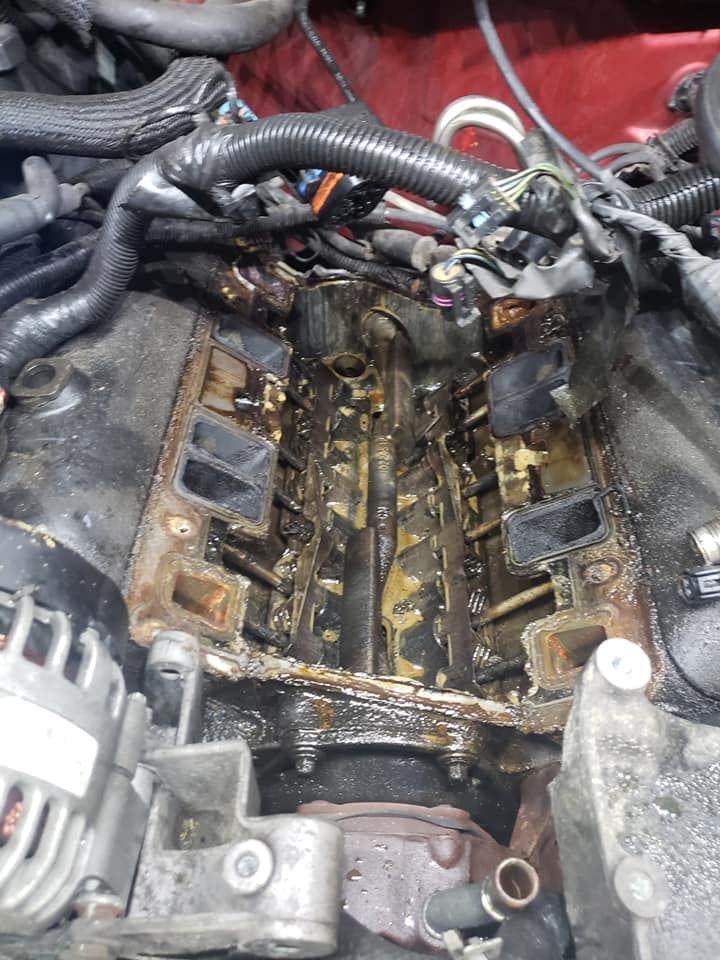 Engine intake manifold with oil residue and components.