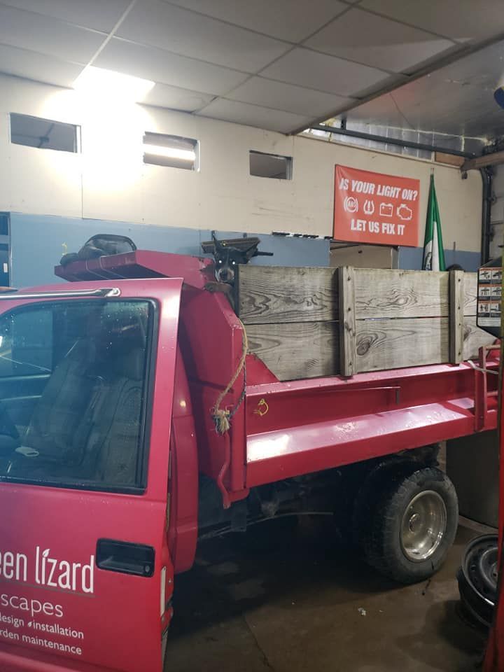 Red pickup truck inside a garage, with wooden crates in the bed. Banner: 