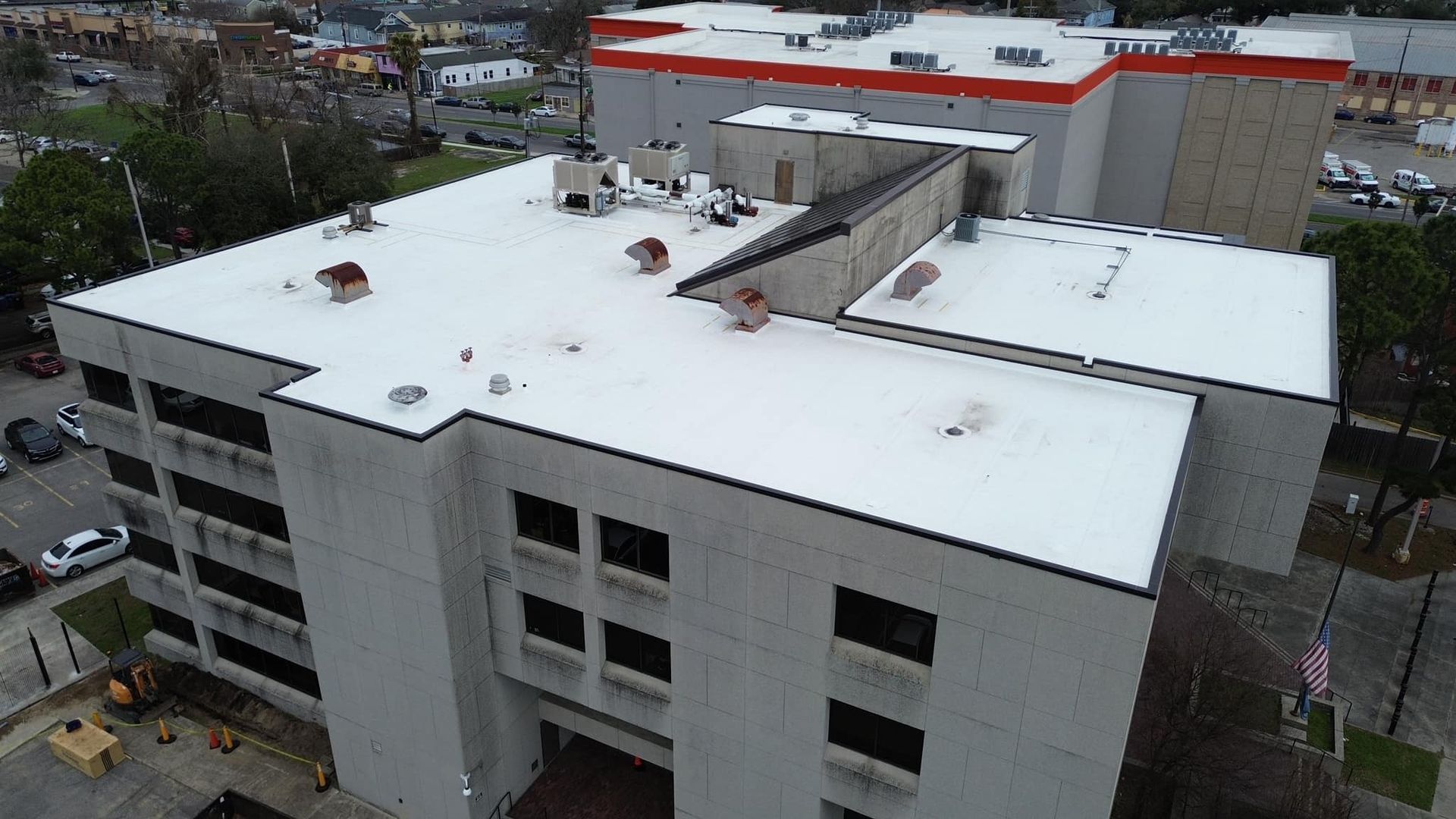 An aerial view of a large building with a white roof.
