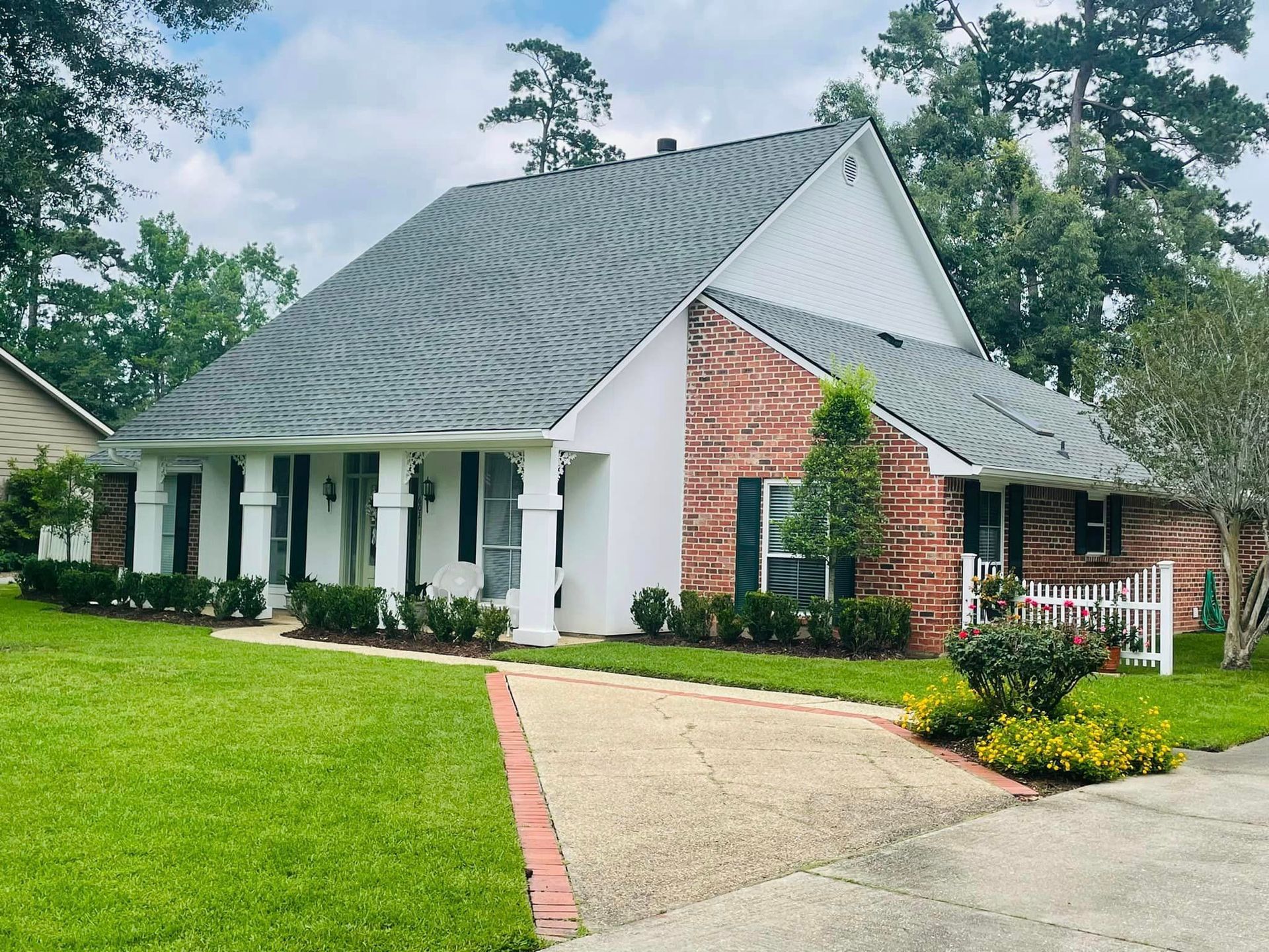 A brick house with a white trim and a gray roof