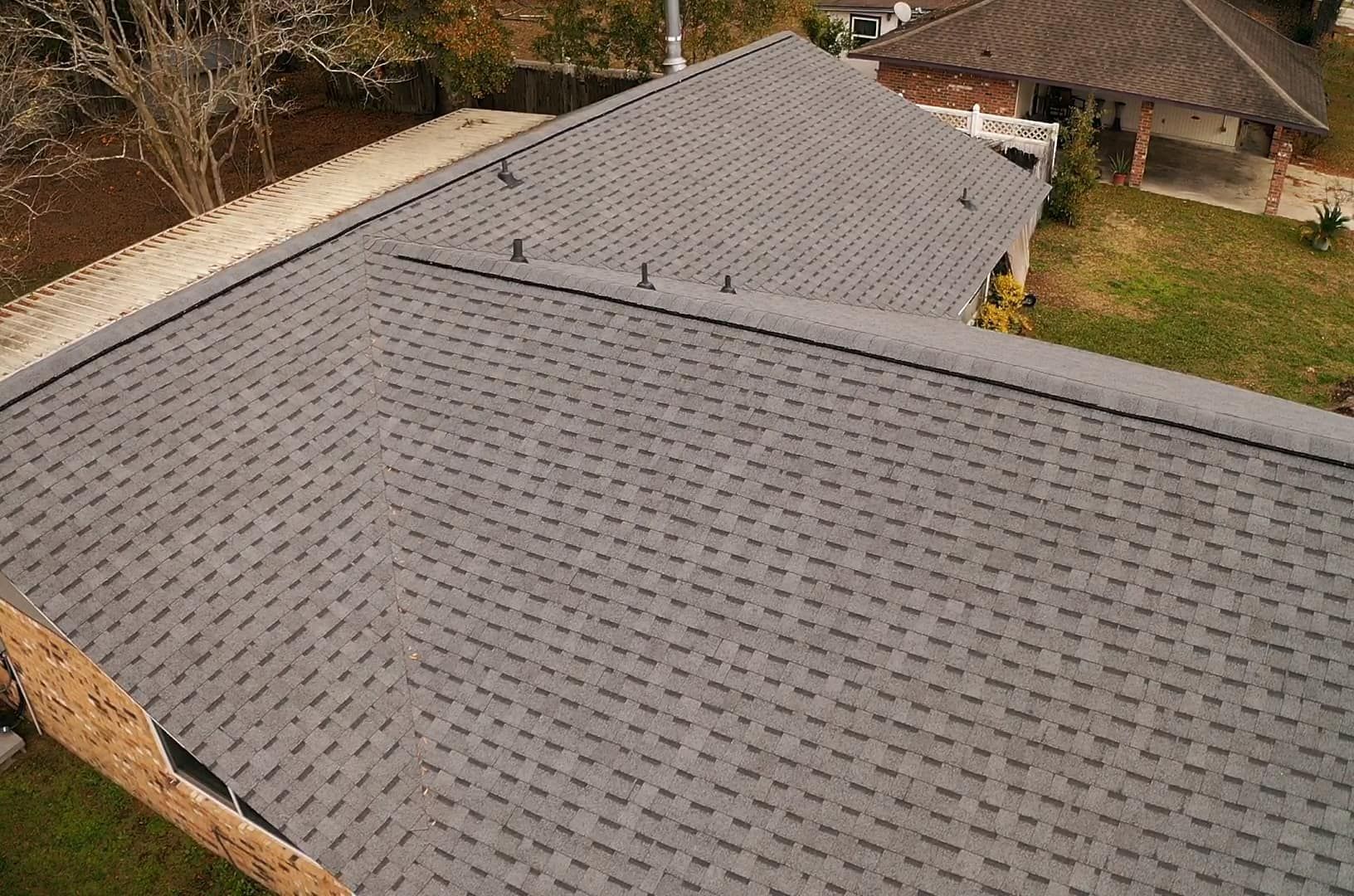 An aerial view of a house with a gray roof