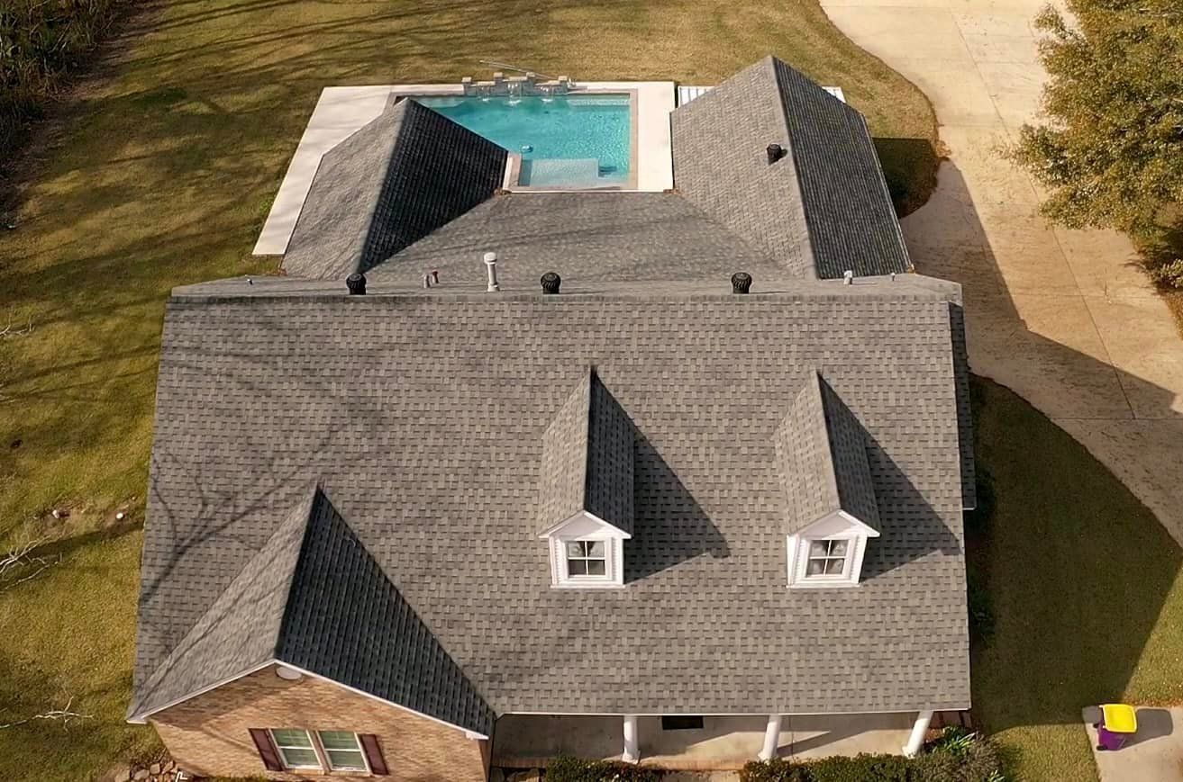 An aerial view of a house with a pool in the backyard