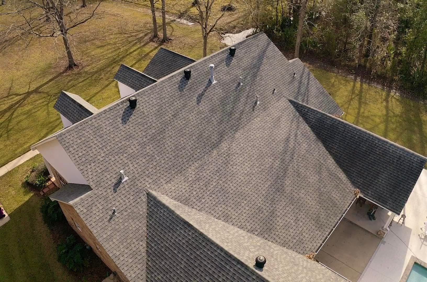 An aerial view of a house with a roof and a pool