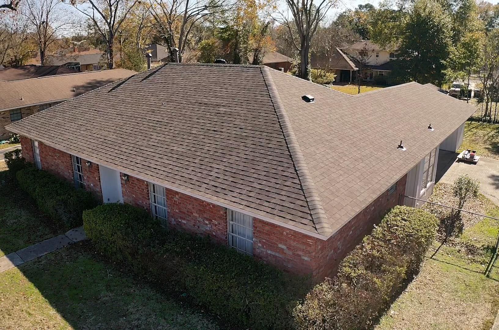 An aerial view of a brick house with a new roof
