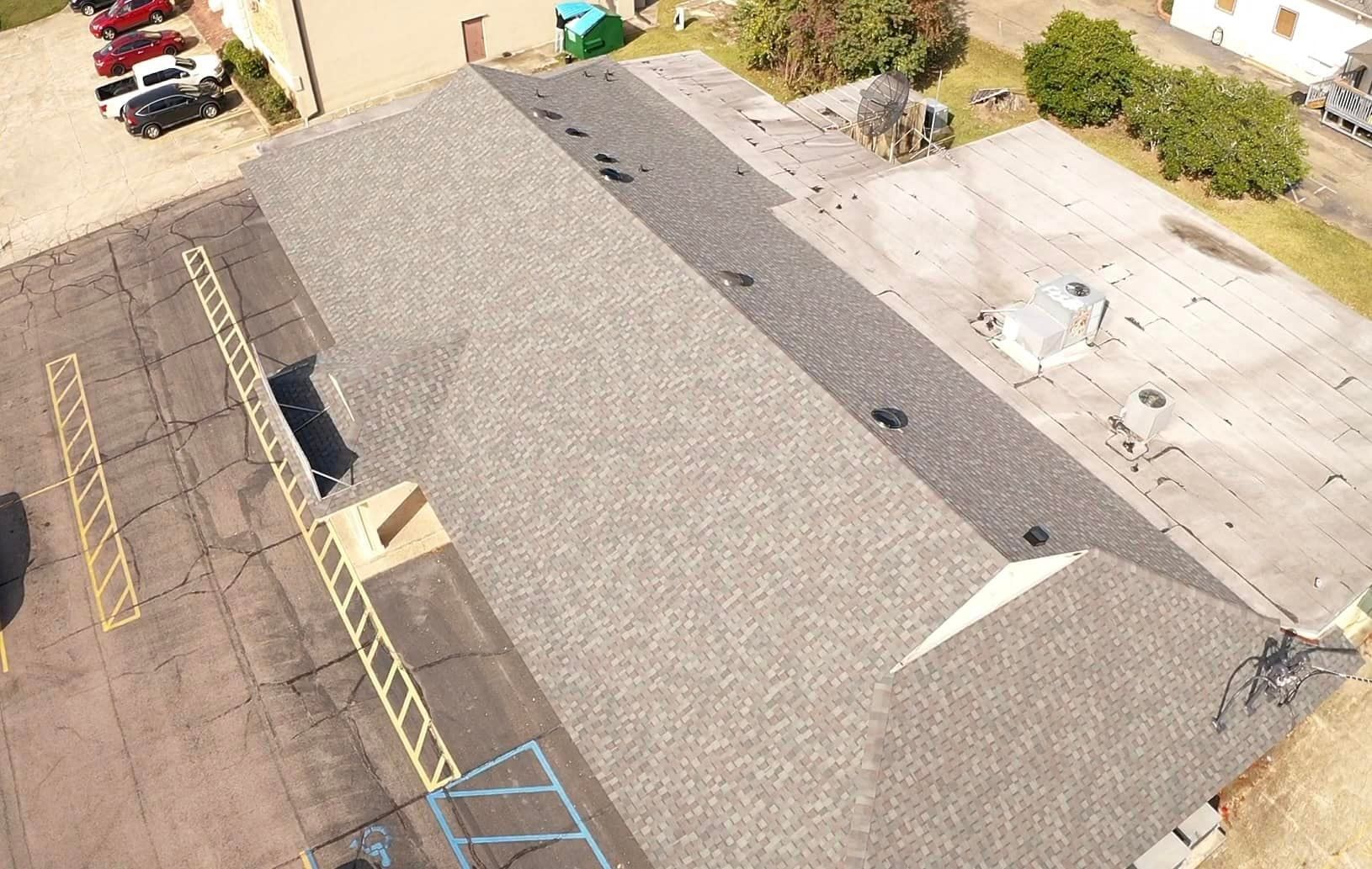 An aerial view of a building with a roof that is being repaired