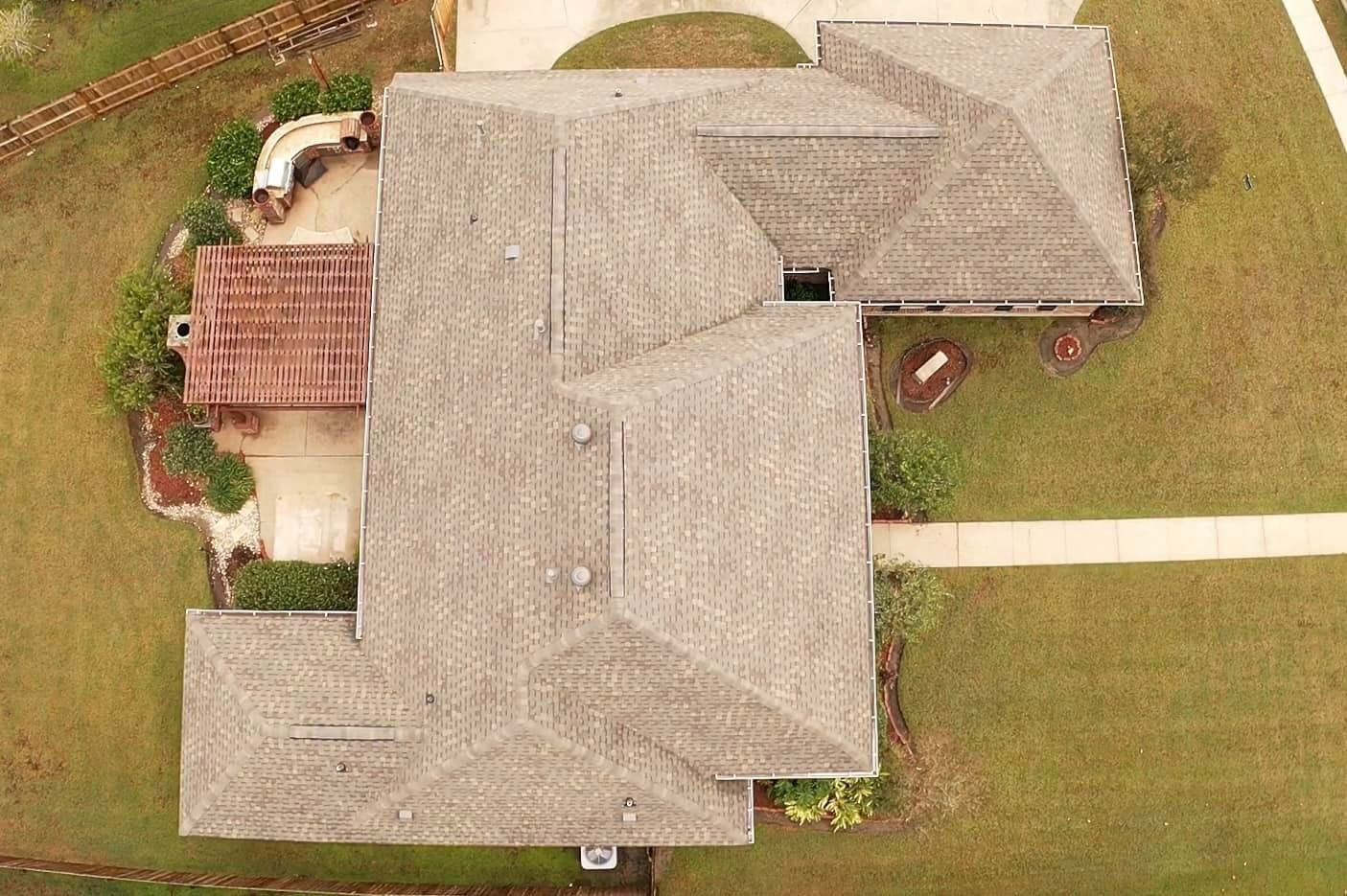 An aerial view of a large house with a roof and a patio
