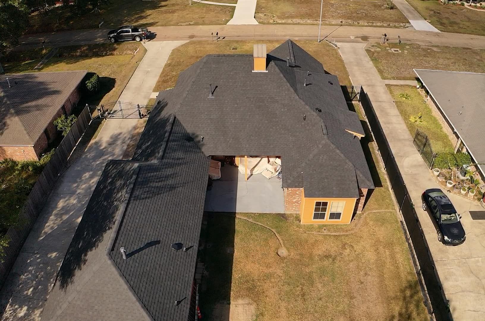 An aerial view of a house with a car parked in front of it