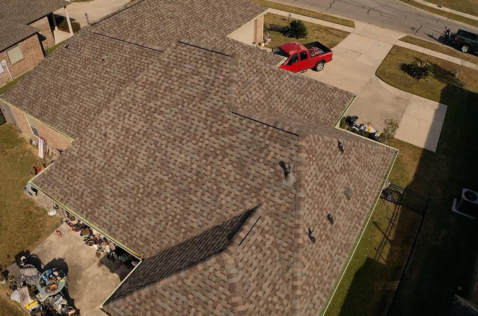 An aerial view of a house with a red truck parked in the driveway