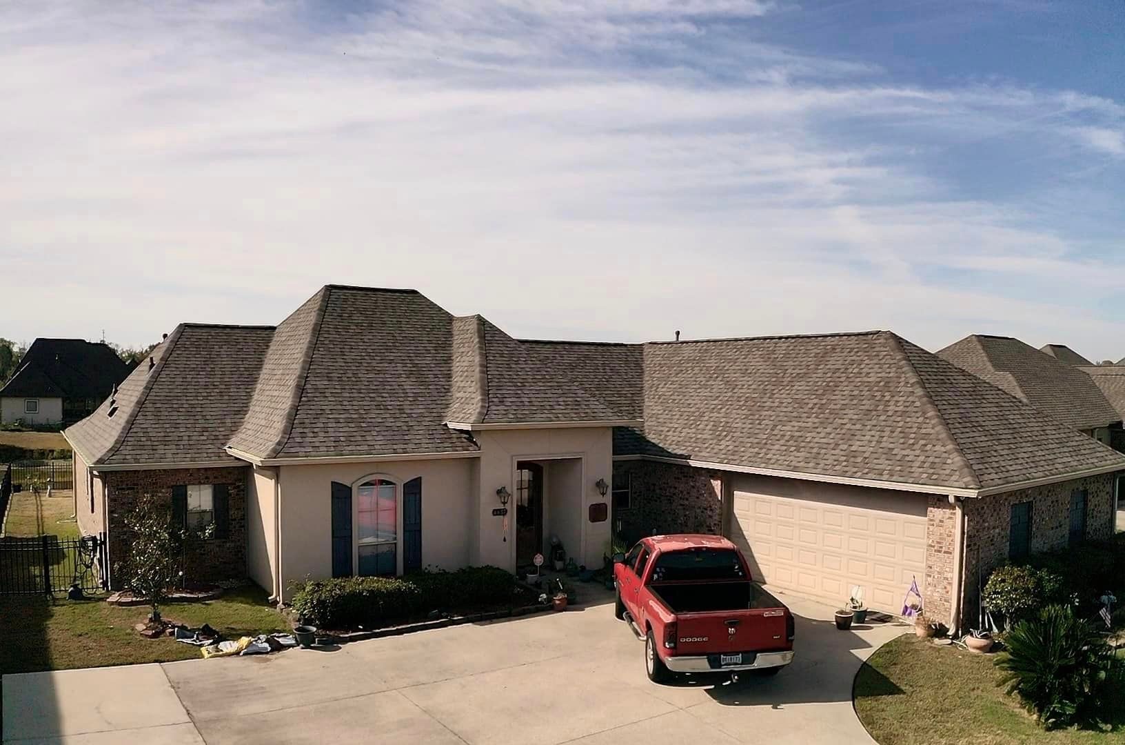 A red truck is parked in front of a house