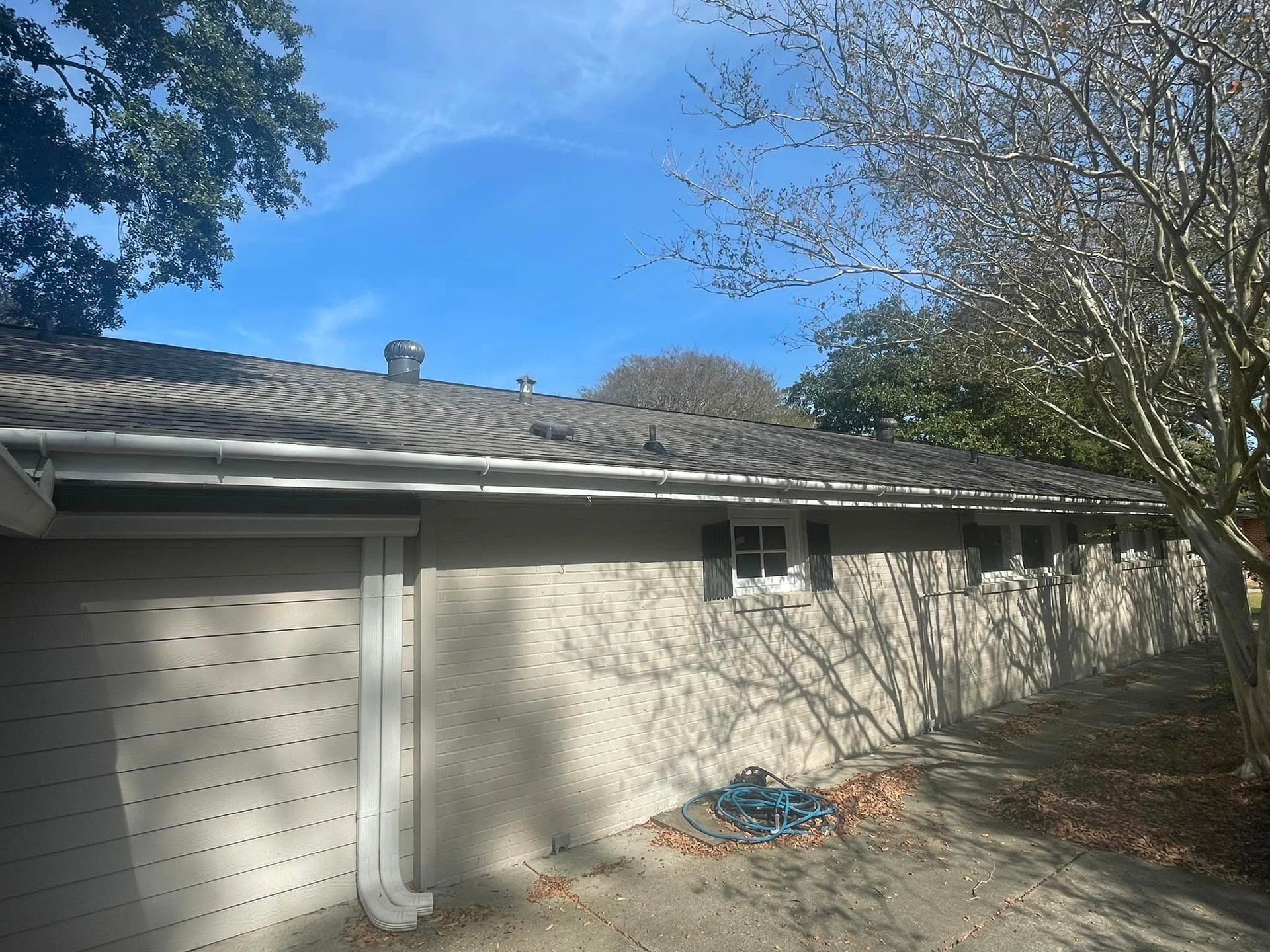 A house with a garage and a tree in front of it