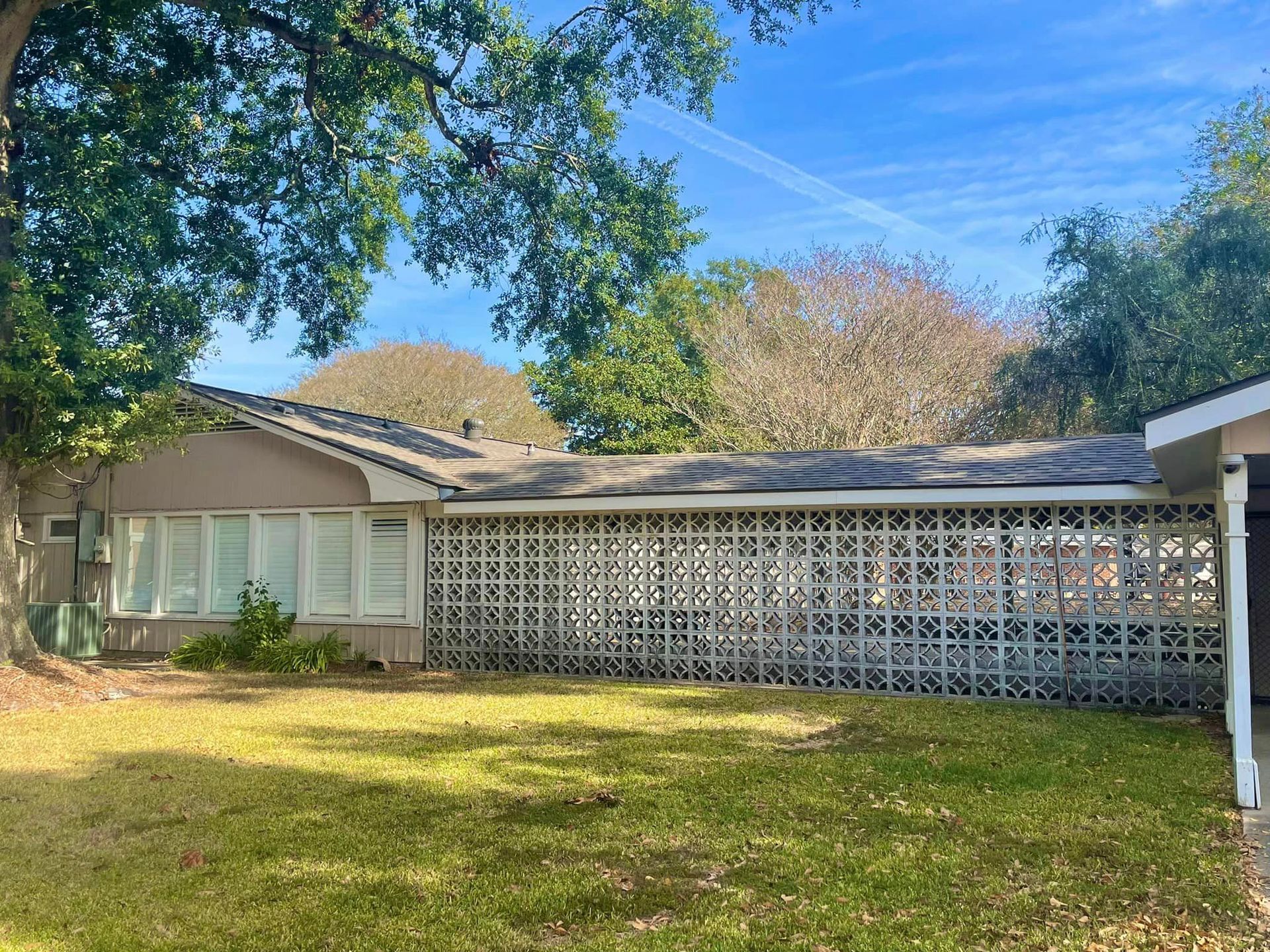 A house with a lot of windows and a fence in front of it