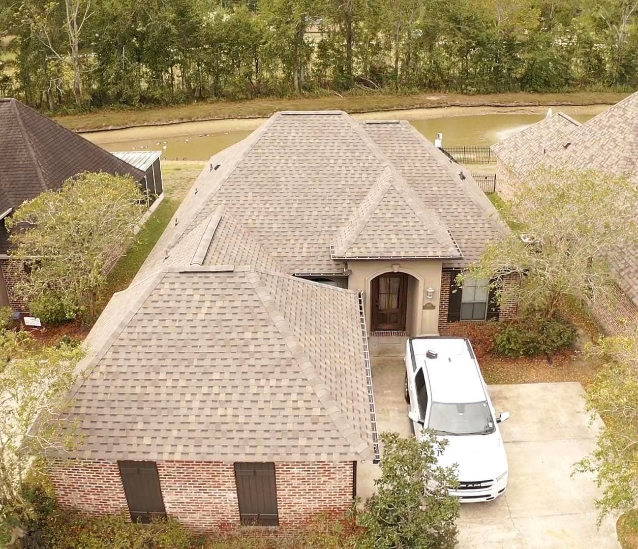 An aerial view of a house with a car parked in front of it