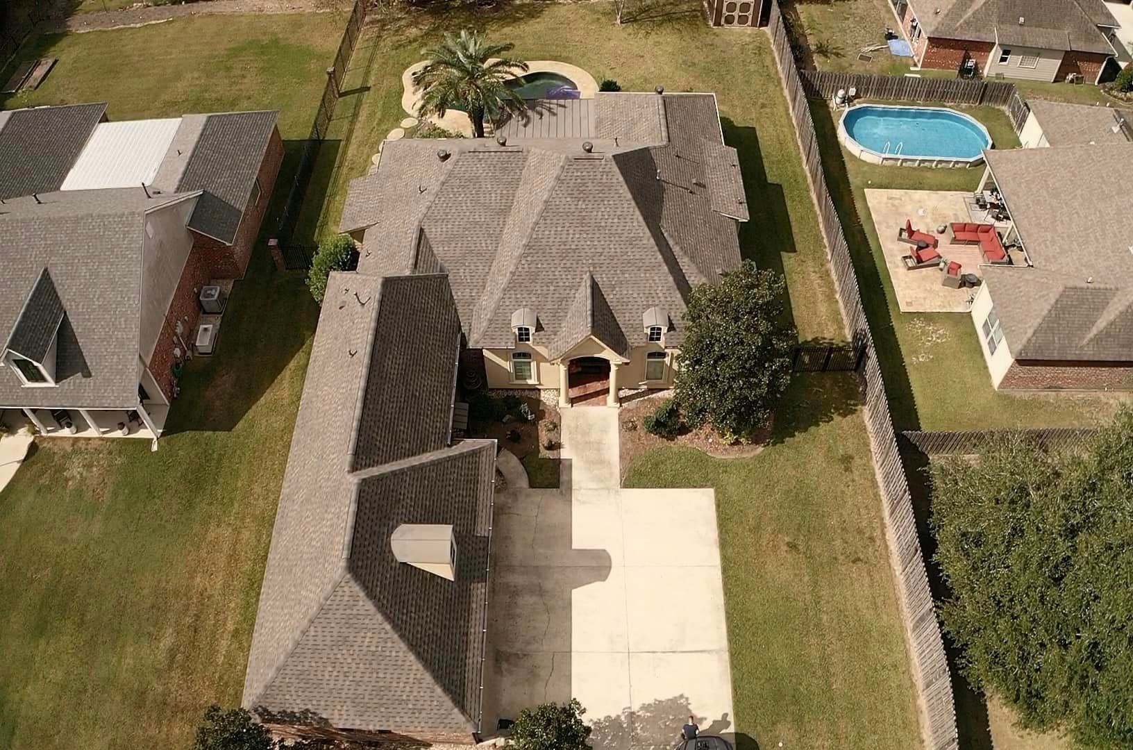An aerial view of a house with a pool in the backyard