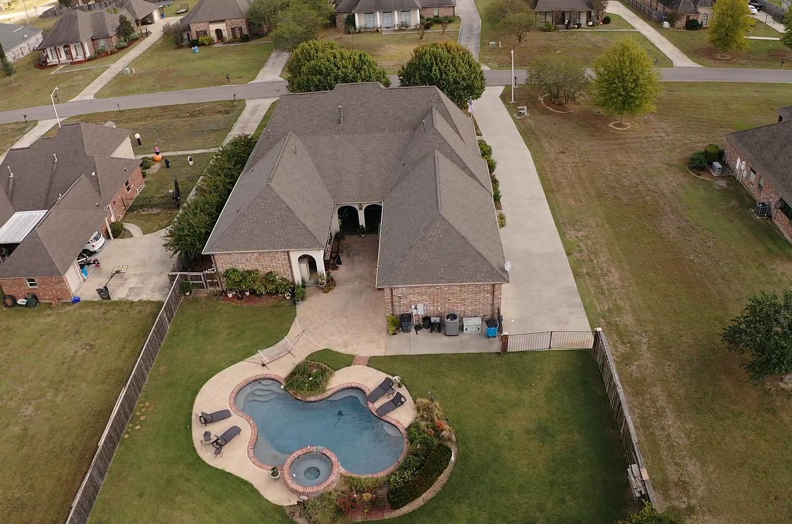 An aerial view of a house with a large pool in the backyard