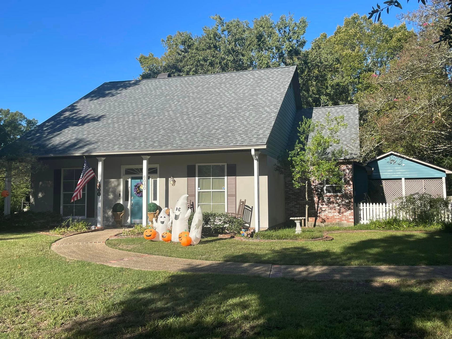 A house with pumpkins in front of it on a sunny day