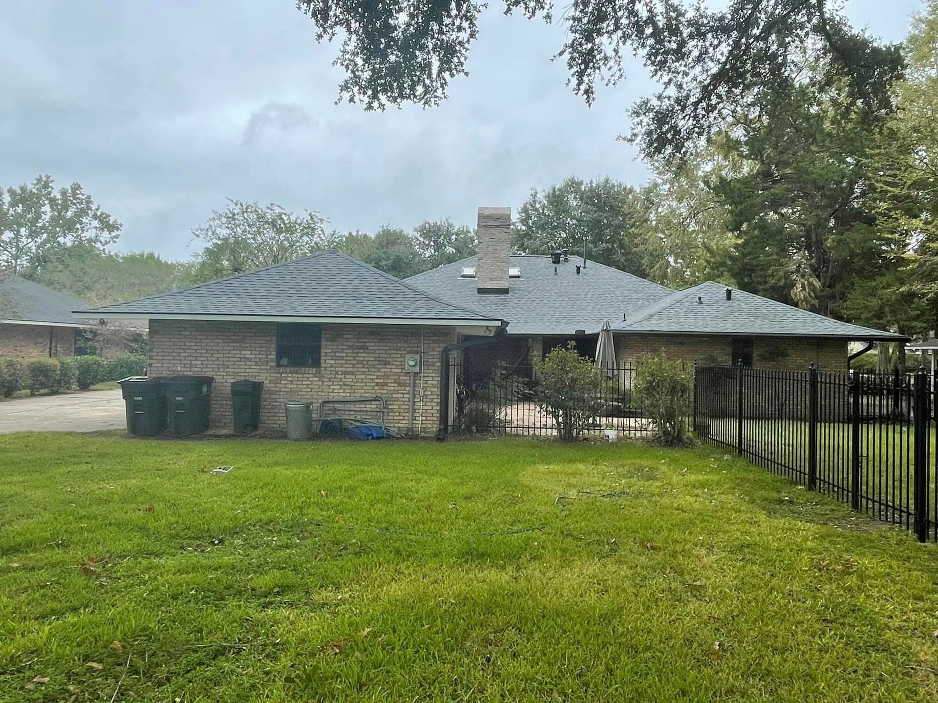 The backyard of a house with a fence and a lot of grass
