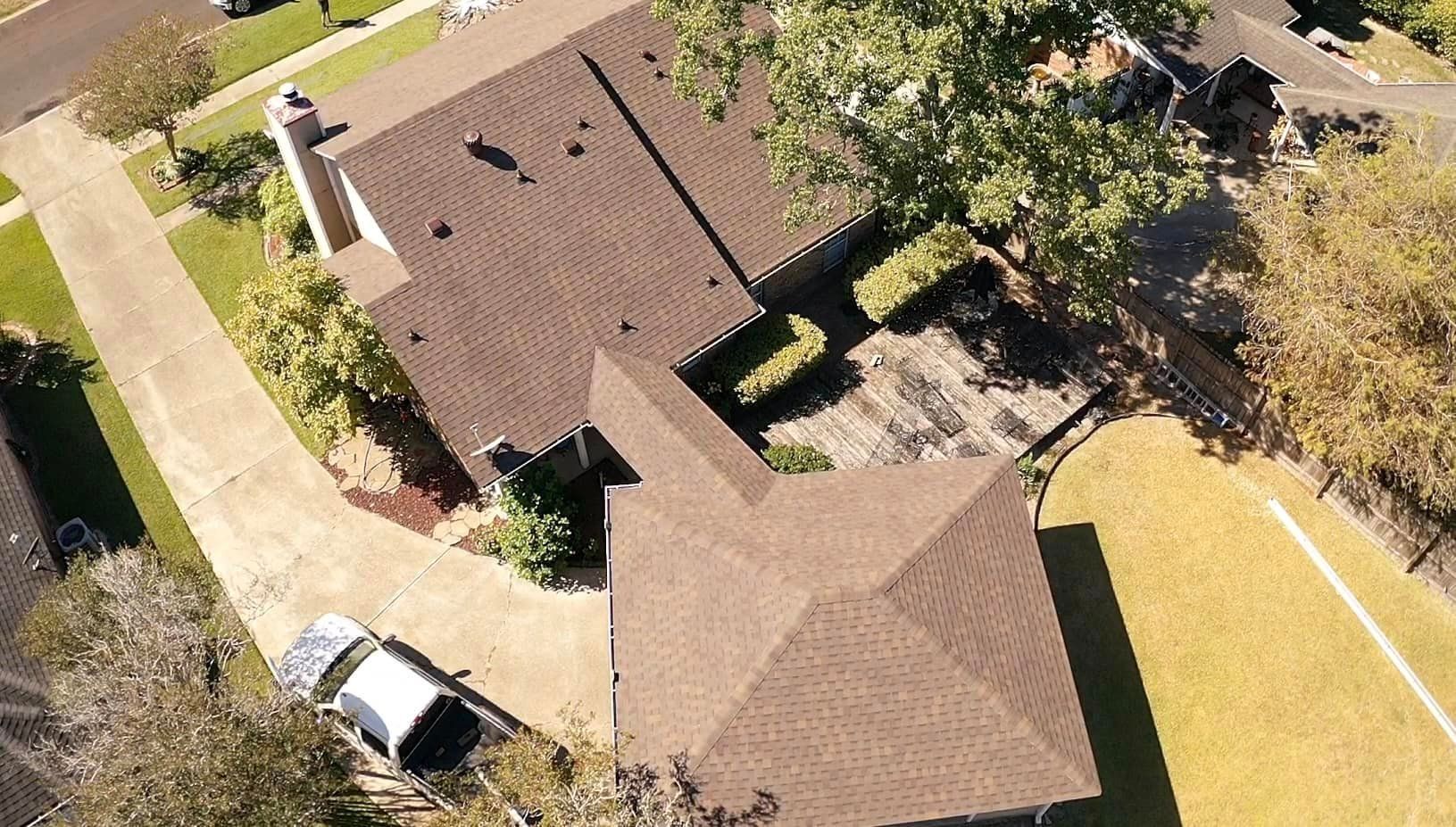 An aerial view of a house with a car parked in front of it