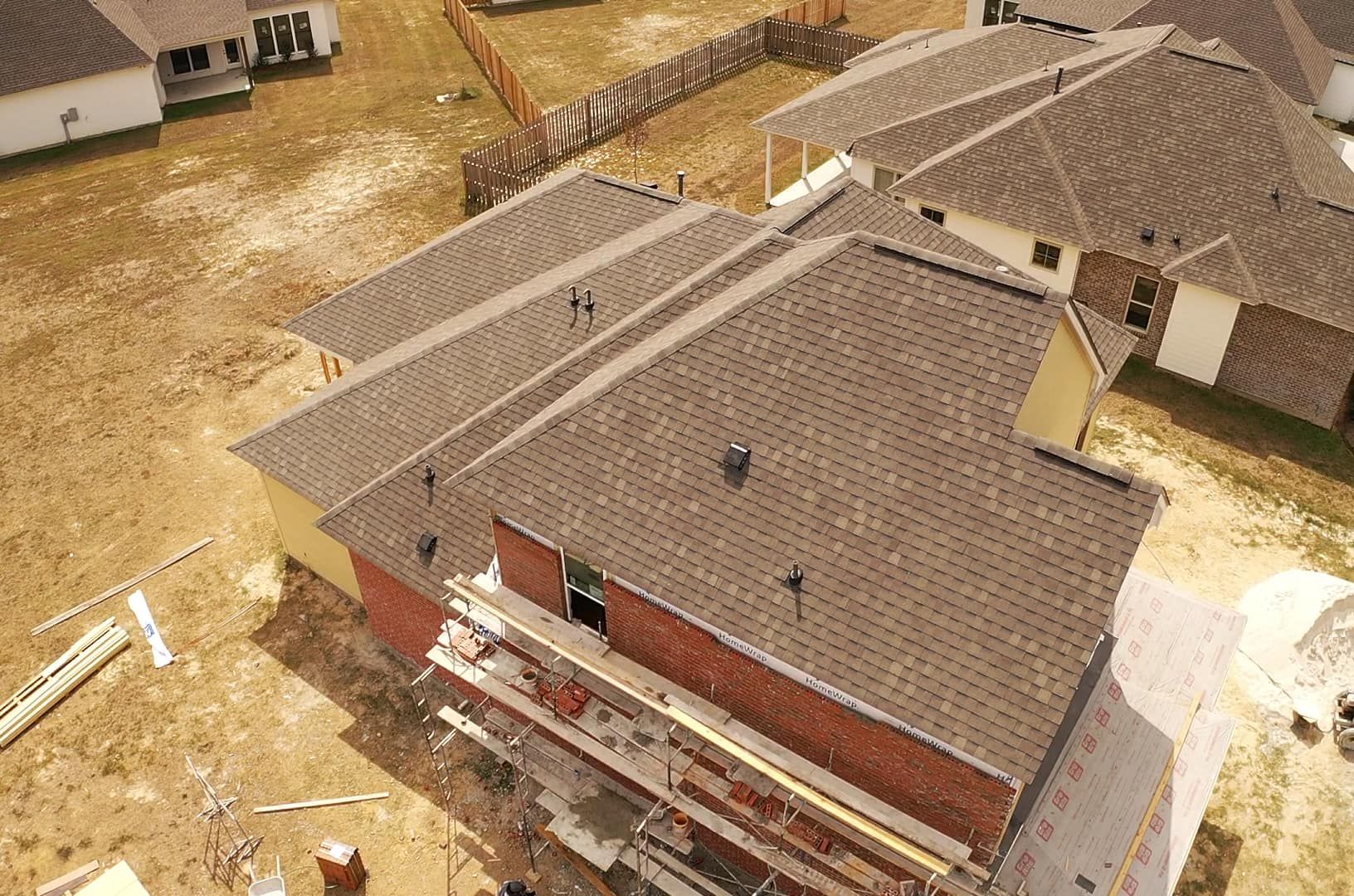 An aerial view of a house under construction in a residential area