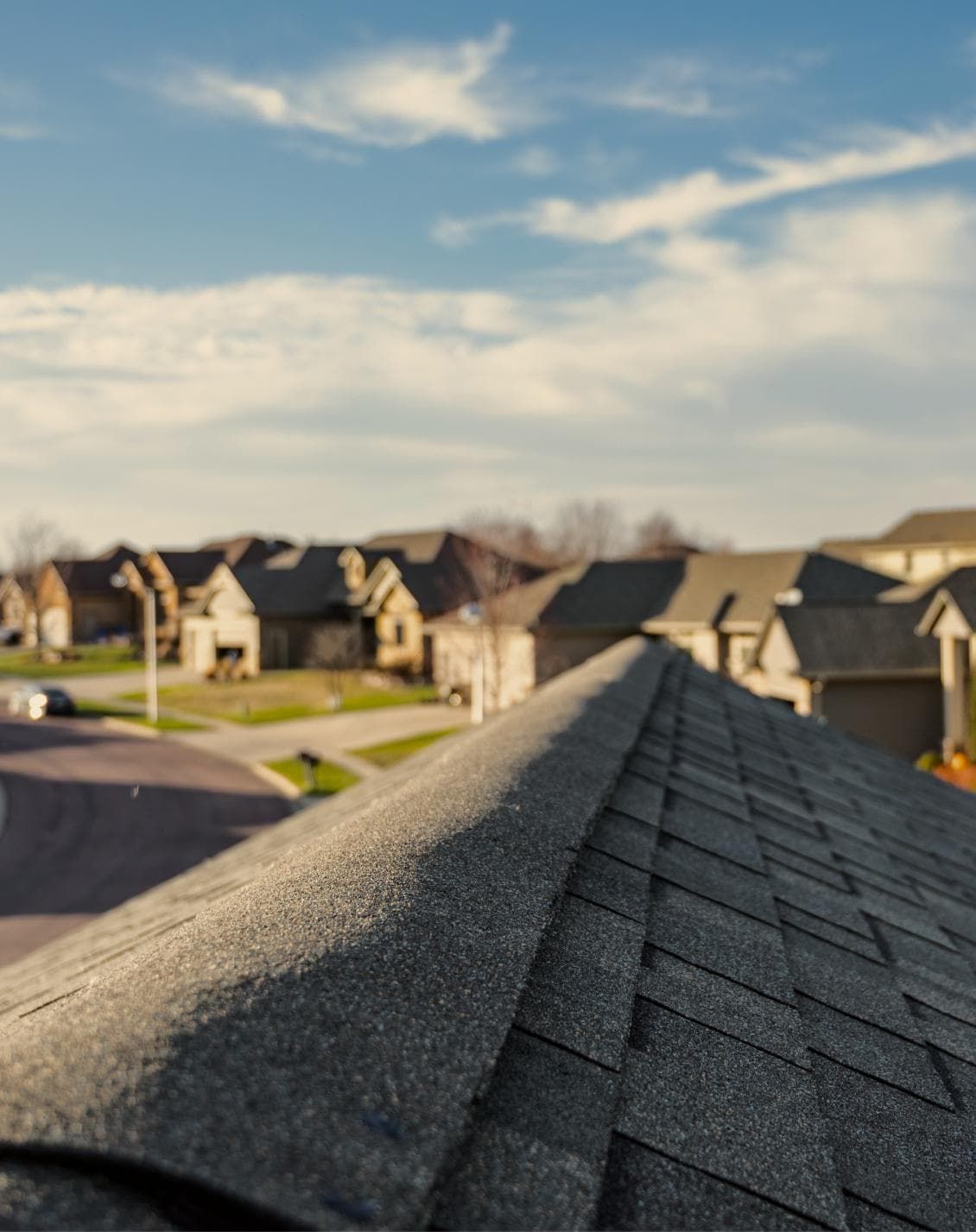 A close up of a roof with a row of houses in the background