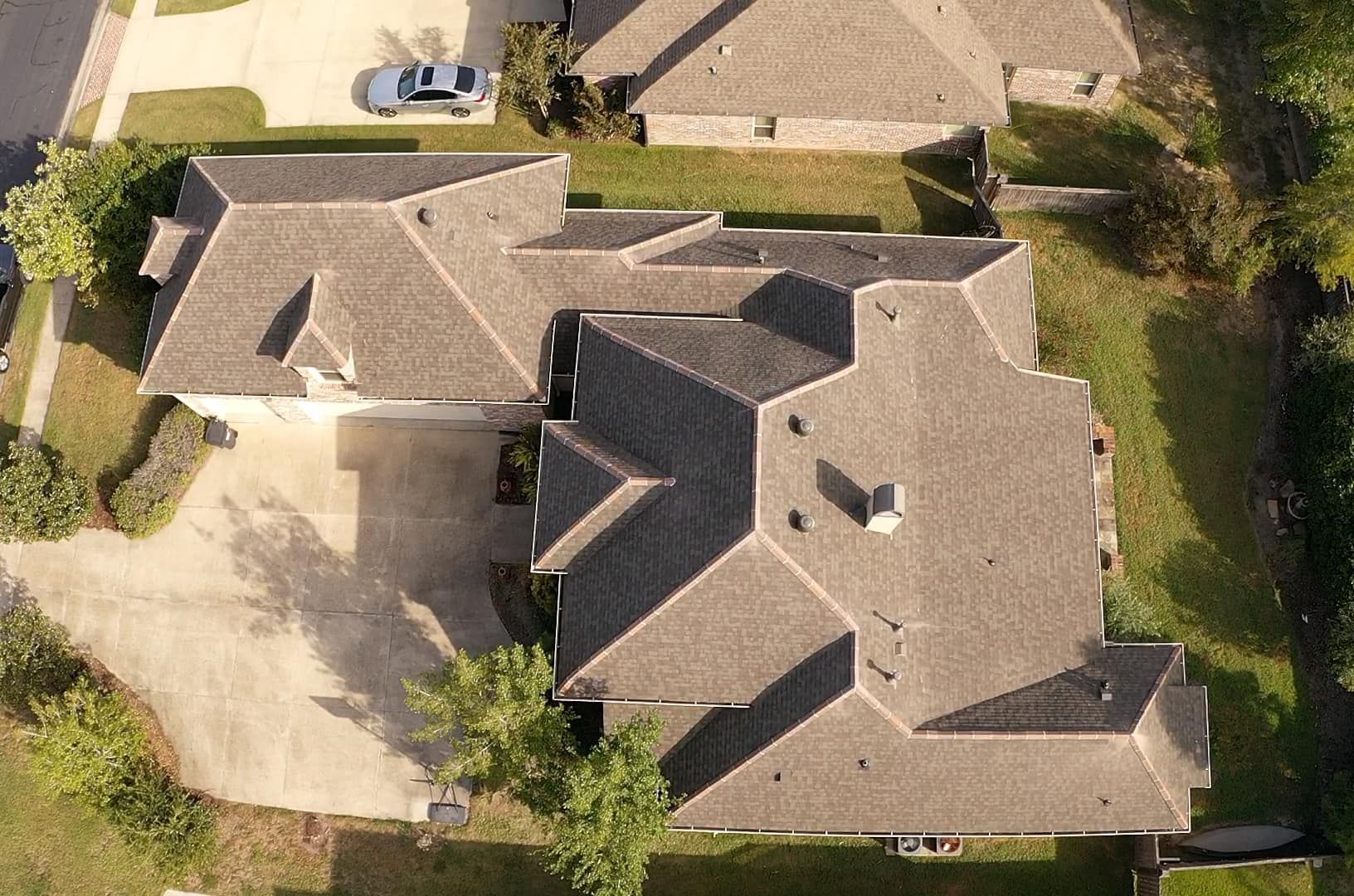 An aerial view of a house with a car parked in the driveway