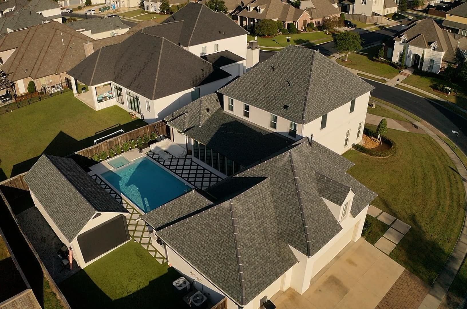An aerial view of a residential area with houses and a pool