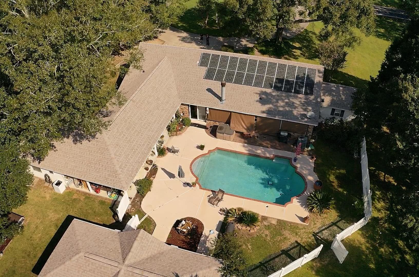 An aerial view of a house with a large swimming pool