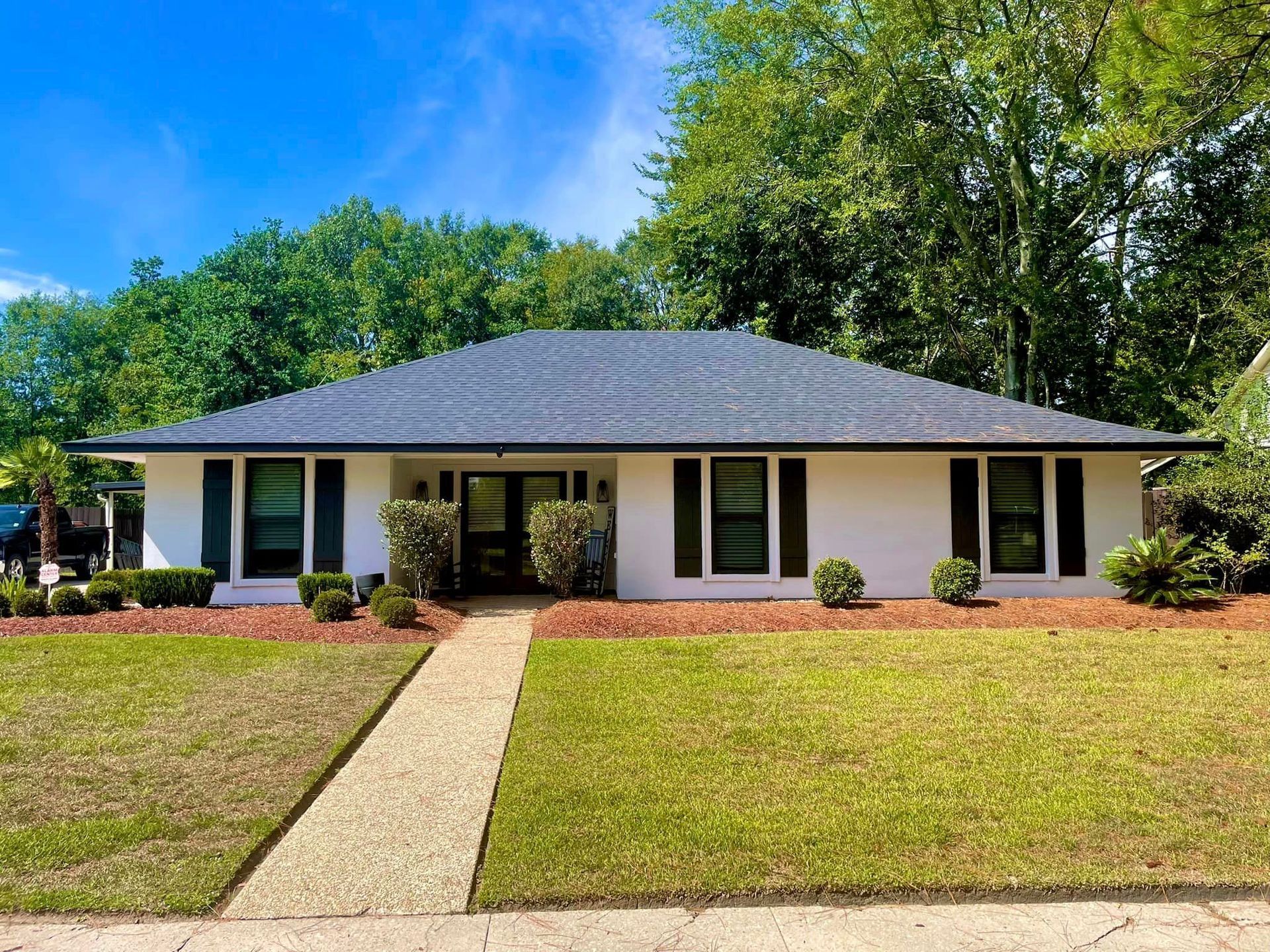 A white house with a black roof and black shutters
