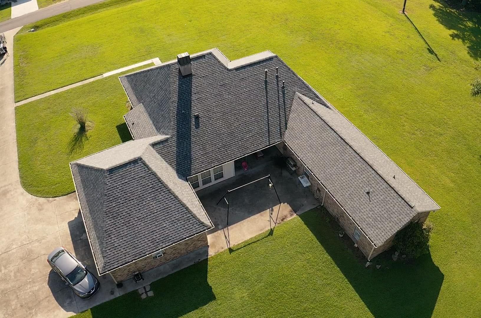 An aerial view of a house with a car parked in front of it