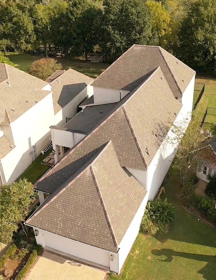 An aerial view of a house with a lot of roofs