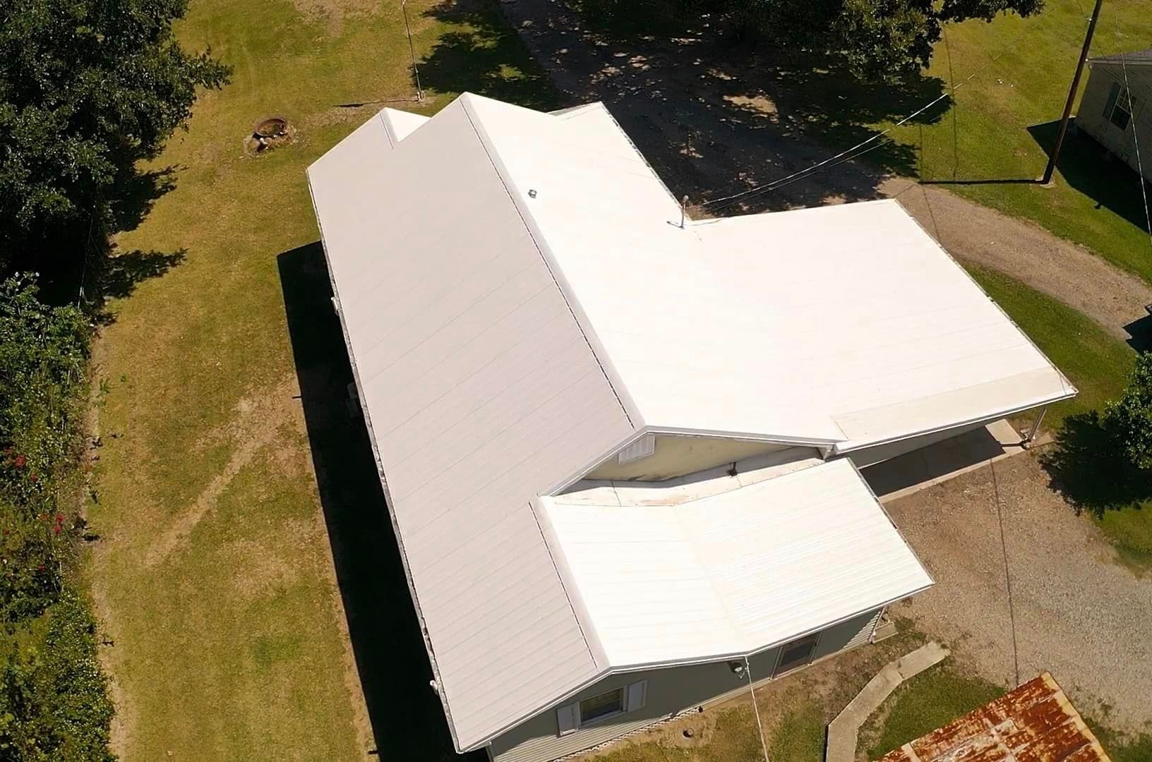 An aerial view of a white house with a white roof