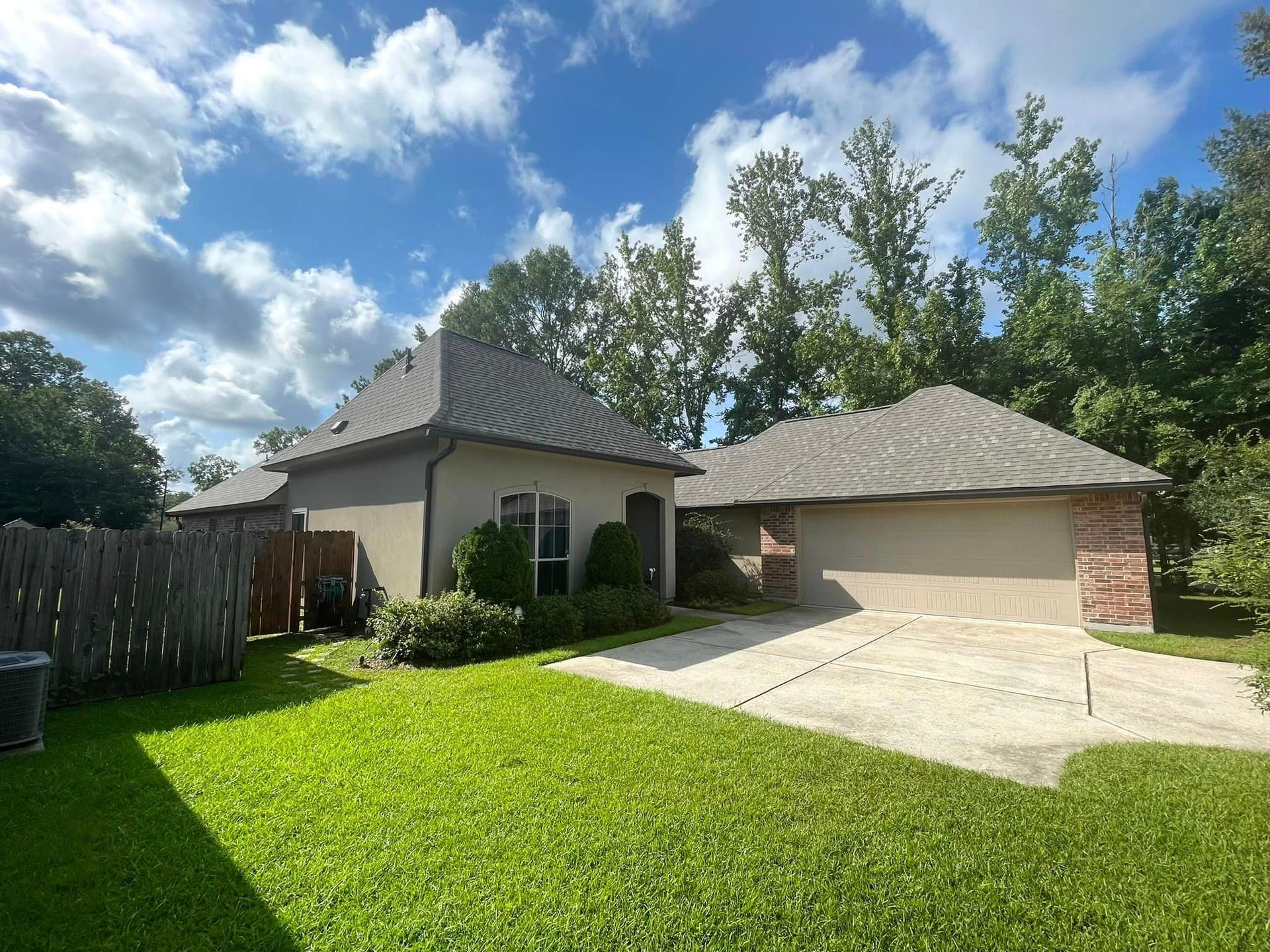A house with a driveway and a fence in front of it