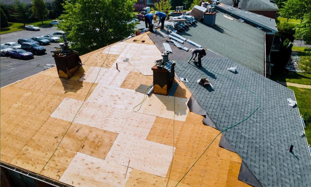 A group of people are working on the roof of a building .