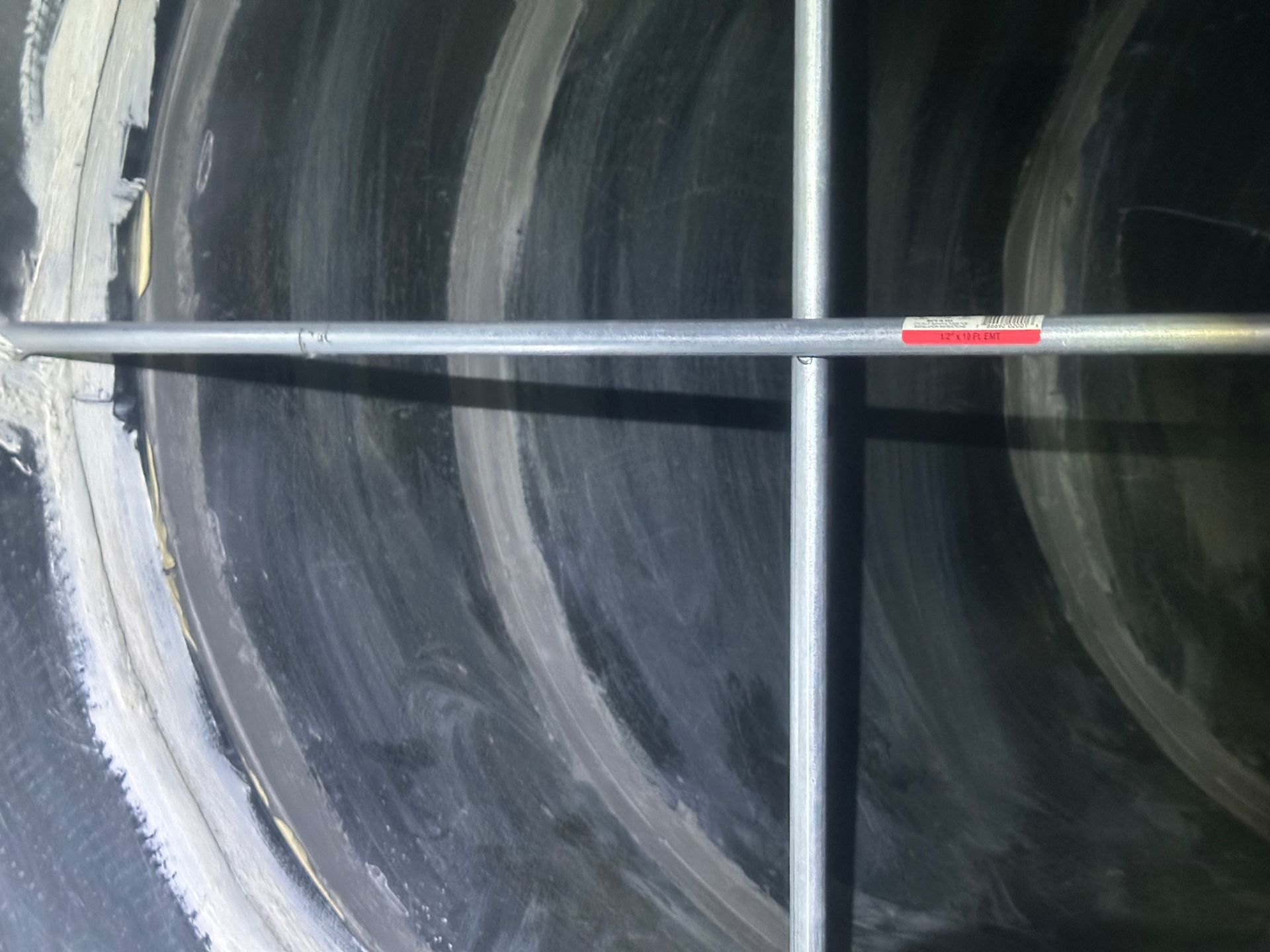 Interior of a dark tunnel with concentric light bands; a metal scaffold spans across.