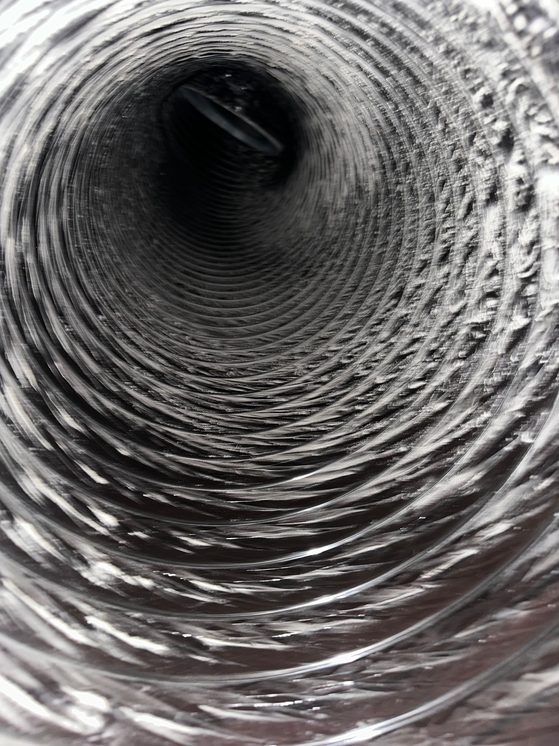 Inside view of a dusty, flexible silver dryer vent.