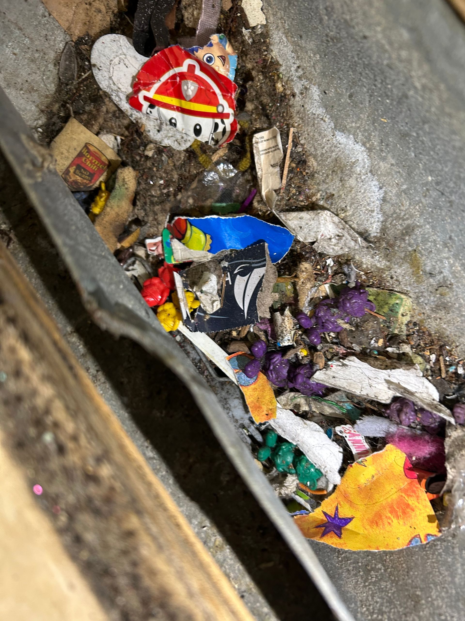 Debris pile with a partially visible spatula. Includes colorful broken toys, including a Fireman Sam figure.