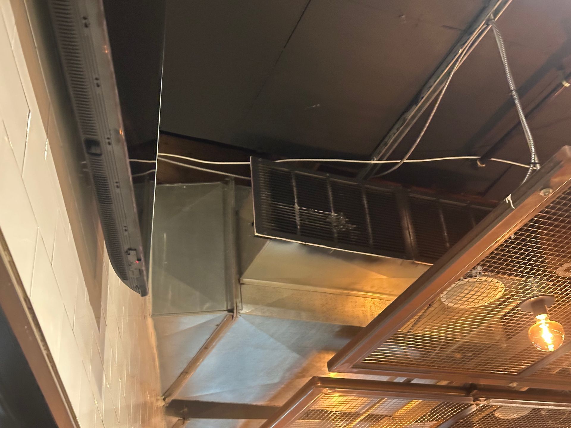 Ventilation ducts and ceiling fixtures in a commercial space.